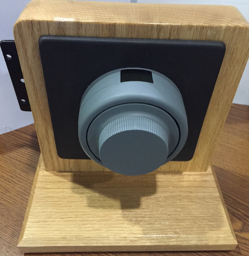 Combination lock mounted on a display structure. The lock is grey and round and has a digital window at the top